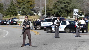 Armed police officers stop traffic in Yucaipa during the manhunt for fugitive former Los Angeles police officer Dorner
