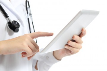 Close up of a woman doctor hand touching a tablet pc