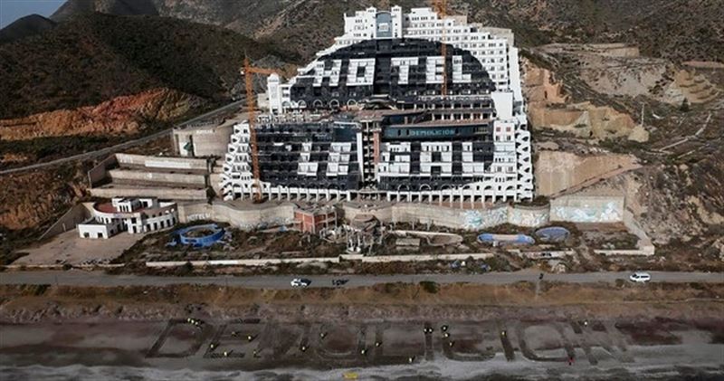 Activistas de Greenpeace escriben ‘Demolición’ frente al hotel del Algarrobico