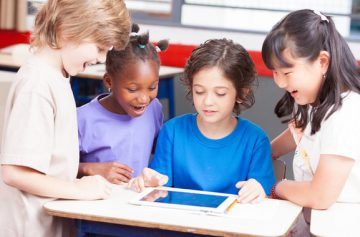Multiethnic classroom playing with tablet Happy school concept El Digital de Asturias Multi-ethnic classroom playing with tablet. Happy school concept.