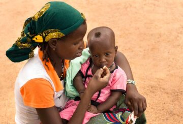 Una madre da de comer a su hijo desnutrido en Burkina Faso