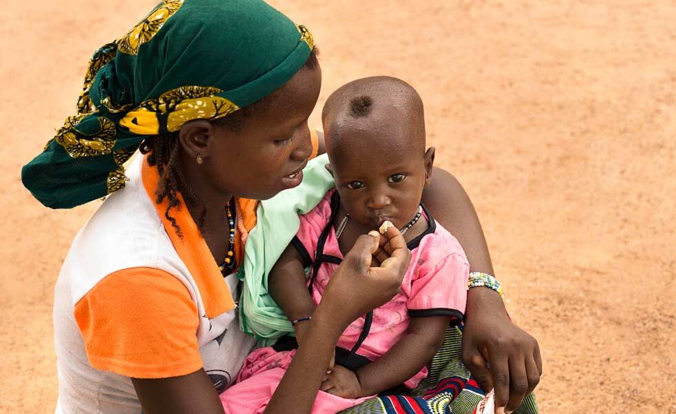 Una madre da de comer a su hijo desnutrido en Burkina Faso